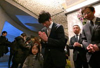 Genki Hasegawa (center) prays before the nameplates of his mother and younger brother who died in the 1995 earthquake, in Chuo Ward, Kobe, on Friday. (Pool photo)