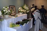 A woman prays in front of a portrait of Tomohiro Kojiri, a reporter killed in the 1987 gun attack on the Asahi Shimbun Hanshin bureau in Nishinomiya, Hyogo Prefecture, Saturday.