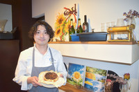Shoichi Kojima, a restaurant owner and chef in Hikone, Shiga Prefecture, holds cheesecake he made with a funazushi ingredient.