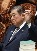 Prime Minister Shigeru Ishiba raises his hand at a House of Representatives Budget Committee meeting on Monday.