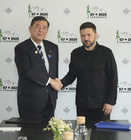 Japanese Prime Minister Shigeru Ishiba (left) shakes hands with Ukrainian President Volodymyr Zelenskyy before their meeting in Kananaskis, Canada, on Tuesday. (Pool photo)