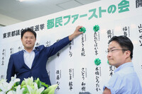 Tomin First no Kai leader Takayuki Morimura (left) places a flower next to the name of a candidate expected to win in Sunday's Tokyo assembly election.