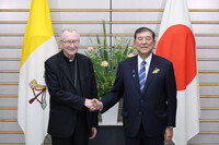Japanese Prime Minister Shigeru Ishiba (right) and Vatican Secretary of State Pietro Parolin shake hands at the prime minister's office in Tokyo on Monday.