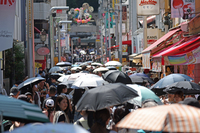 People walk on a street in Tokyo's Shibuya Ward on June 28 with umbrellas to block the sunlight.