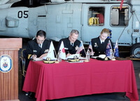 Japanese Maritime Self-Defense Force Rear Adm. Naoya Hoshi (left), U.S. Navy Vice Adm. Jeff Jablon (center) and Royal Australian Navy Commodore Catherine Rhodes (right) sign an agreement to enhance cooperation for underway replenishment, aboard the U.S. Navy's USS America amphibious assault ship anchored in Brisbane, Australia, on Friday. (Courtesy of the MSDF)