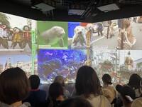 Visitors watch a promotion video shown at the booth of Mie Prefecture at the venue of the World Exposition in Osaka on May 18.