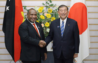 Japanese Prime Minister Shigeru Ishiba (right) and Papua New Guinea's Prime Minister James Marape (left) shake hands at the prime minister's office in Tokyo on Tuesday.