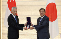Japanese Prime Minister Shigeru Ishiba (right) presents the Grand Cordon of the Order of the Rising Sun to Singapore's Senior Minister and former Prime Minister Lee Hsien Loong at the prime minister's office in Tokyo on Monday.